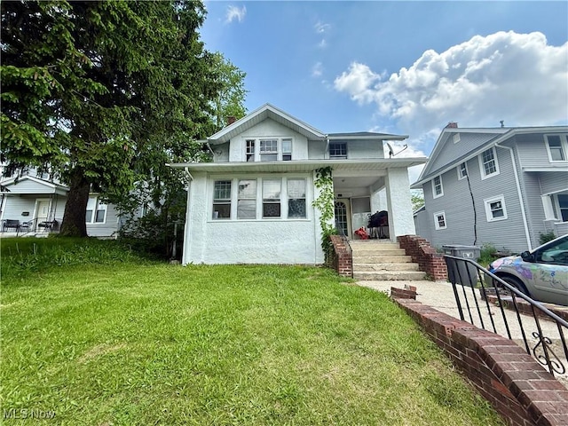 327 Garfield Ave, Lima, OH 45805 - view of front facade featuring a porch, a front yard, and stucco siding