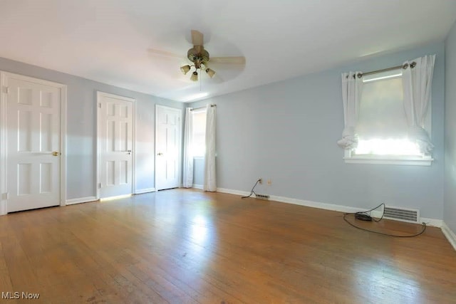 4020 Colony Rd, South Euclid, OH 44121 - unfurnished bedroom with wood finished floors, baseboards, multiple closets, and ceiling fan