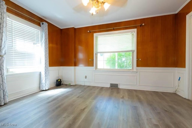 4020 Colony Rd, South Euclid, OH 44121 - empty room featuring crown molding, ceiling fan, wood finished floors, and wainscoting