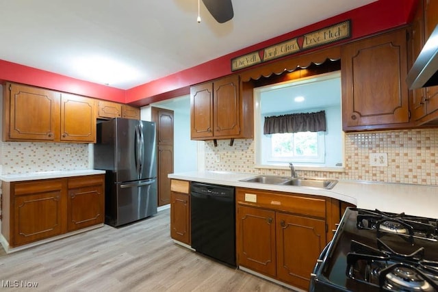 4020 Colony Rd, South Euclid, OH 44121 - kitchen featuring black appliances, a sink, backsplash, wall chimney range hood, and light countertops