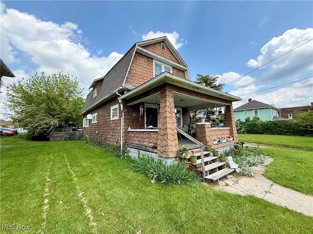 924 W Elm St, Lima, OH 45801 - view of front facade featuring a porch, a front yard, a gambrel roof, and a shingled roof