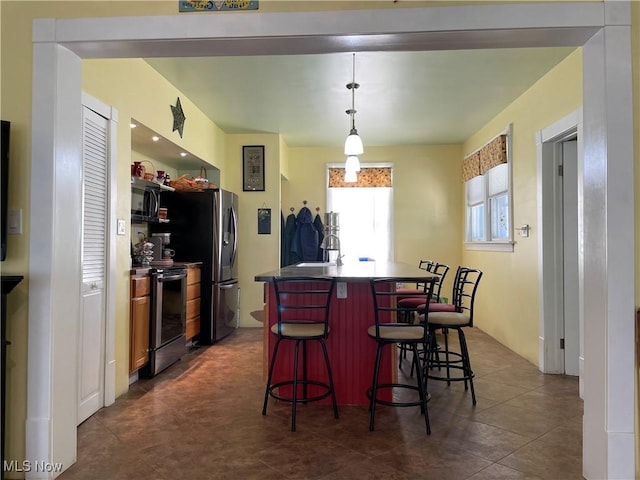 1605 E 46th St, Ashtabula, OH 44004 - kitchen featuring electric range, black microwave, an island with sink, a kitchen bar, and dark countertops