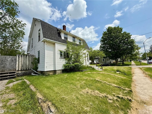 503 N Charles St, Lima, OH 45805 - view of home's exterior with a chimney, a shingled roof, a yard, and a gambrel roof