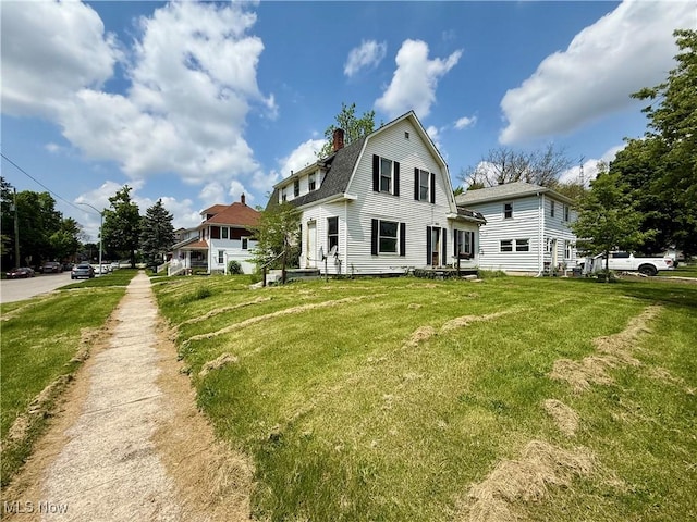 503 N Charles St, Lima, OH 45805 - back of house featuring a gambrel roof, a chimney, a lawn, and roof with shingles