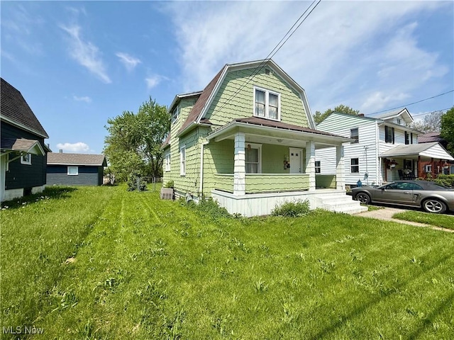 731 N Baxter St, Lima, OH 45801 - colonial inspired home featuring a porch, a front lawn, and a gambrel roof