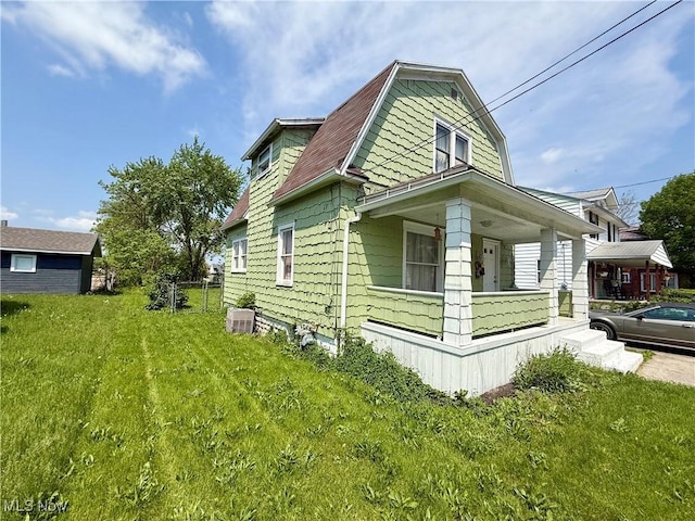 731 N Baxter St, Lima, OH 45801 - view of home's exterior with a porch, a lawn, and a gambrel roof
