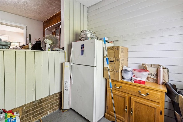 4202 Walter Ave, Parma, OH 44134 - kitchen with freestanding refrigerator, concrete floors, wooden walls, and brown cabinets