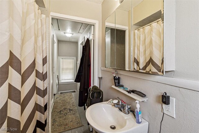 4202 Walter Ave, Parma, OH 44134 - bathroom with a sink, a textured wall, and curtained shower