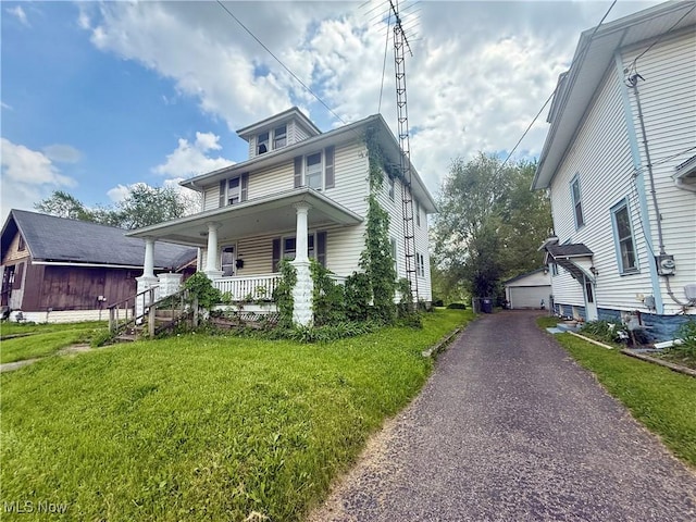 812 E Vine St, Lima, OH 45804 - traditional style home featuring a porch, an outbuilding, a front lawn, and a detached garage