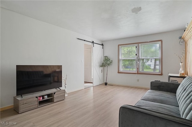 7182 Stewart Sharon Rd, Hubbard, OH 44425 - living room featuring a barn door, wood finished floors, and baseboards