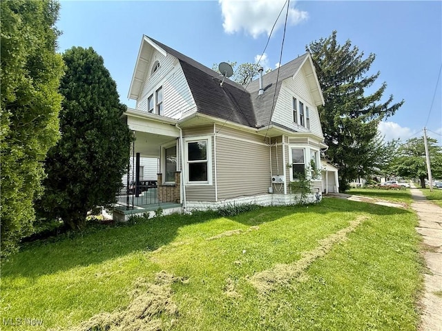 431 N Metcalf St, Lima, OH 45801 - view of home's exterior featuring a porch, a yard, a gambrel roof, a garage, and a shingled roof