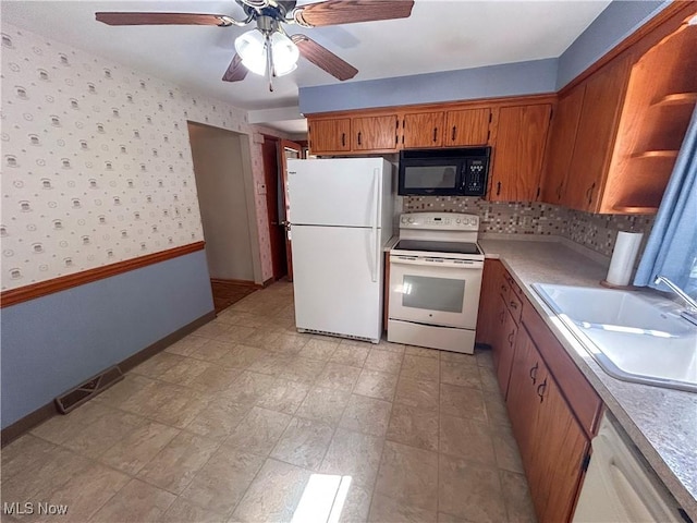 100 Chadwick Ln, Austintown, OH 44515 - kitchen featuring white appliances, a sink, brown cabinets, ceiling fan, and light countertops
