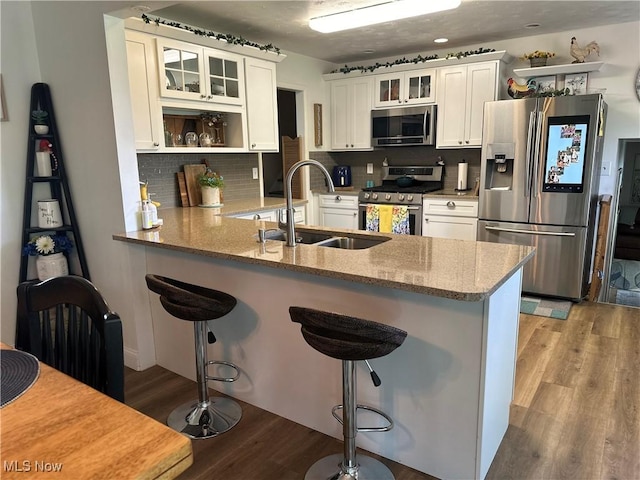 59010 Palmer St, Byesville, OH 43723 - kitchen featuring stainless steel appliances, a sink, a peninsula, light wood-style floors, and tasteful backsplash