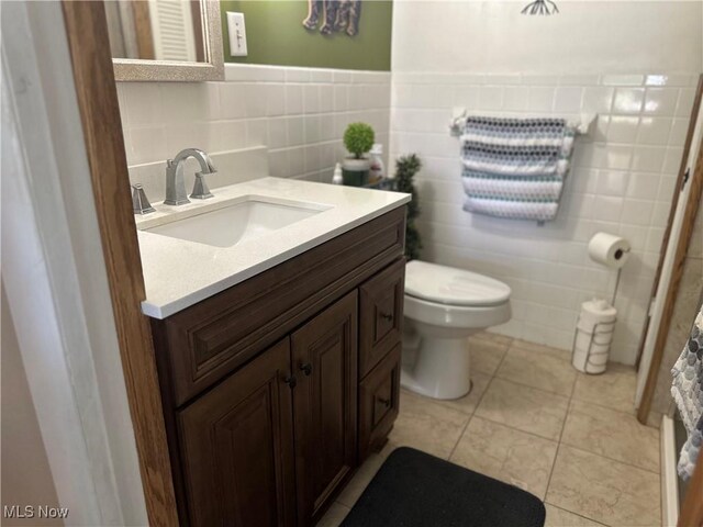 59010 Palmer St, Byesville, OH 43723 - bathroom with toilet, tile walls, vanity, and tile patterned floors