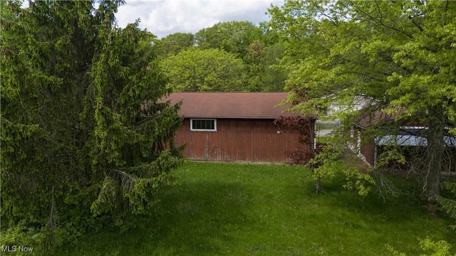 view of property exterior featuring a lawn and an outdoor structure