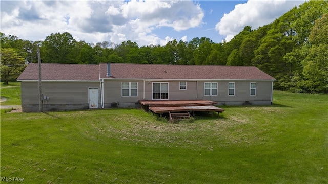 rear view of property featuring crawl space, a yard, a view of trees, and a wooden deck