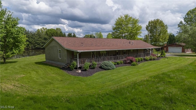 back of property with a porch, a detached garage, a lawn, and an outdoor structure