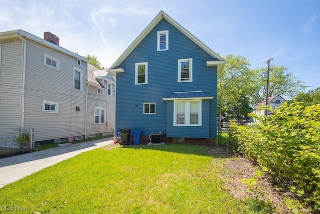 2205 W 85th St, Cleveland, OH 44102 - rear view of property with central air condition unit and a lawn