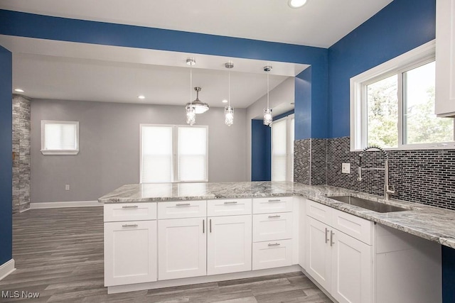 2205 W 85th St, Cleveland, OH 44102 - kitchen with a sink, a peninsula, light stone counters, light wood-style flooring, and recessed lighting