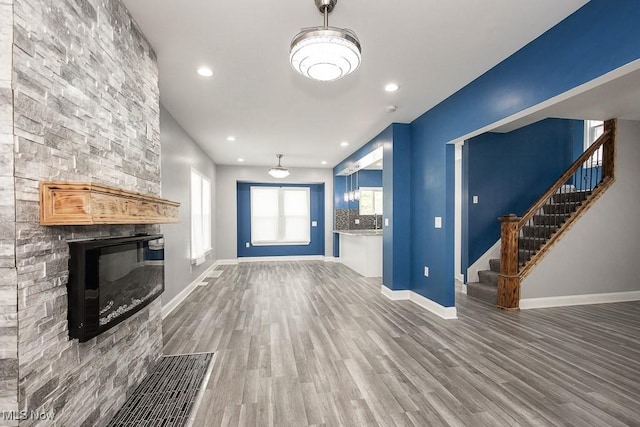 2205 W 85th St, Cleveland, OH 44102 - unfurnished living room with wood finished floors, stairway, baseboards, a fireplace, and recessed lighting
