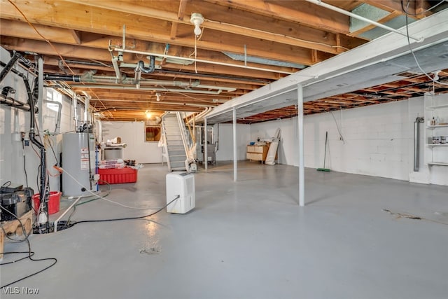 unfinished below grade area featuring gas water heater and stairway
