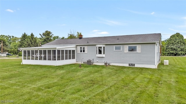 back of house with central AC unit, a sunroom, and a yard