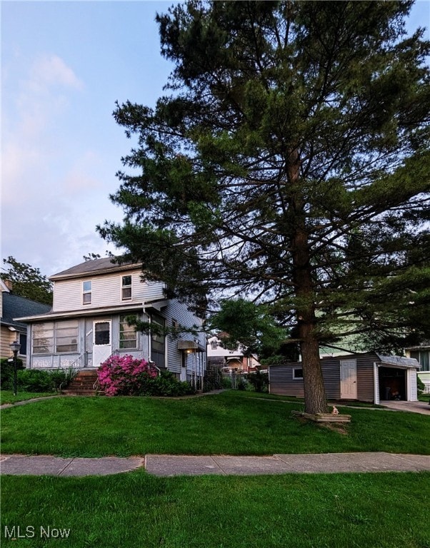 view of front of home featuring a front yard and a detached garage