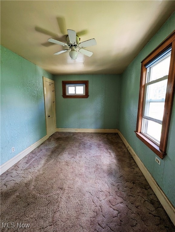 spare room with ceiling fan, carpet, a textured wall, and baseboards
