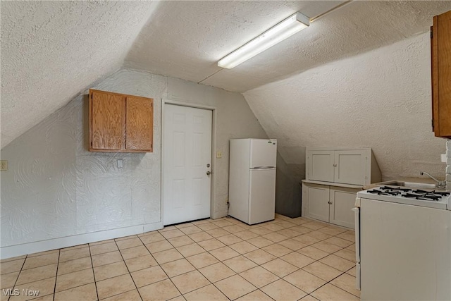 124 Beck Ave, Akron, OH 44302 - kitchen with white appliances, a textured ceiling, vaulted ceiling, and light tile patterned floors