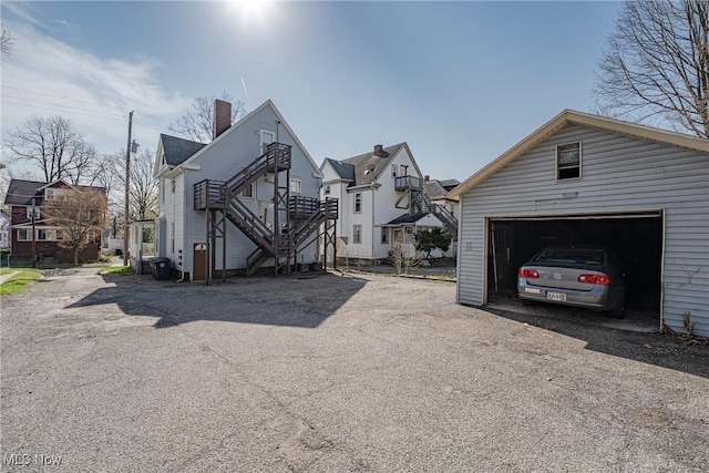 124 Beck Ave, Akron, OH 44302 - view of home's exterior featuring stairs, a residential view, a garage, and a chimney