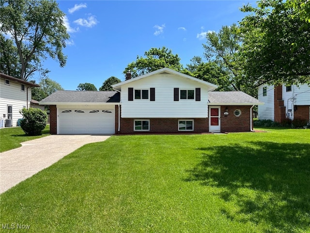 5135 Berkshire Dr, North Olmsted, OH 44070 - split level home featuring a garage, a front yard, concrete driveway, brick siding, and a chimney