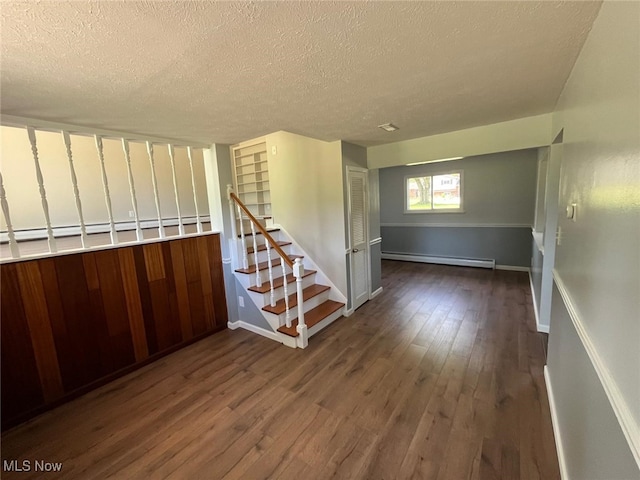 5135 Berkshire Dr, North Olmsted, OH 44070 - stairs featuring a baseboard heating unit, a textured ceiling, wood finished floors, and baseboards