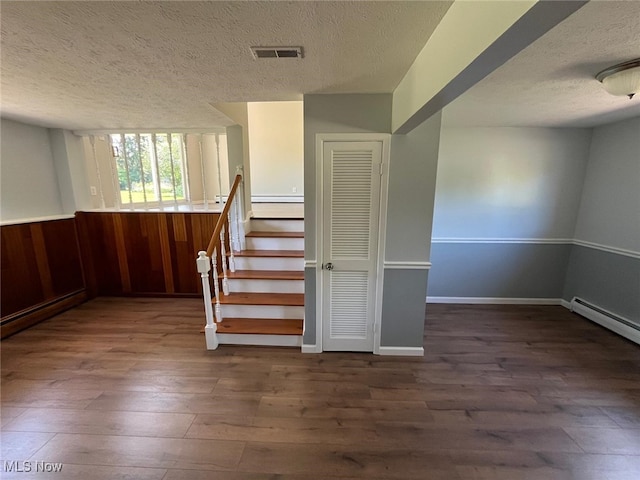 5135 Berkshire Dr, North Olmsted, OH 44070 - staircase with a textured ceiling, wood finished floors, a wainscoted wall, wooden walls, and a baseboard heating unit