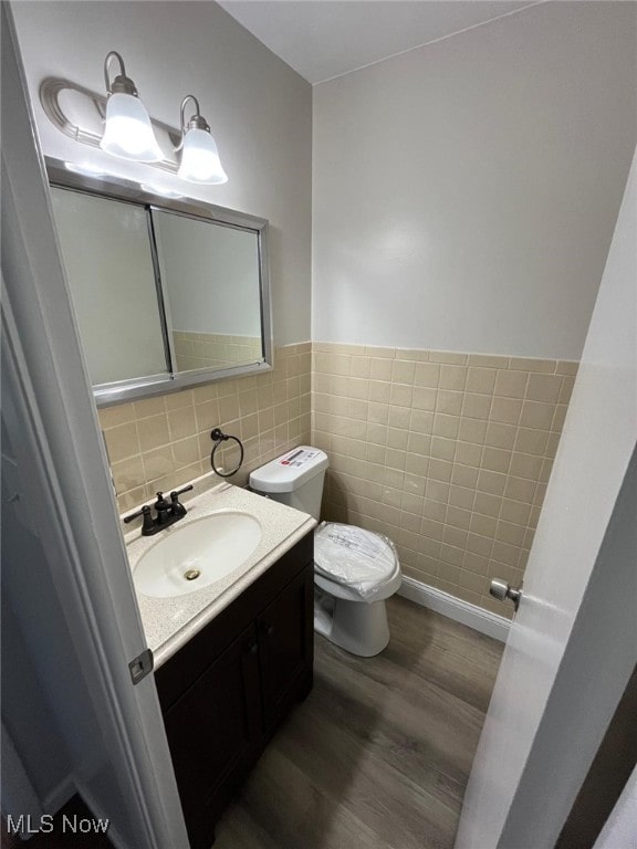 5135 Berkshire Dr, North Olmsted, OH 44070 - bathroom with tile walls, wood finished floors, toilet, vanity, and wainscoting