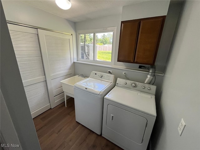 5135 Berkshire Dr, North Olmsted, OH 44070 - laundry room featuring washer and dryer, cabinet space, dark wood finished floors, and a textured ceiling