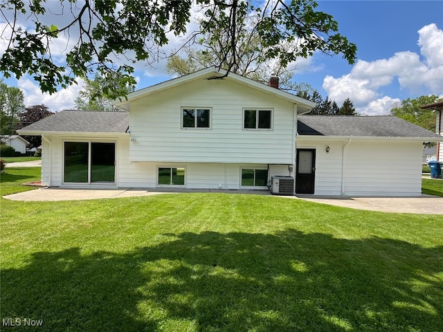 5135 Berkshire Dr, North Olmsted, OH 44070 - back of house featuring a patio area, a lawn, a chimney, a shingled roof, and central AC