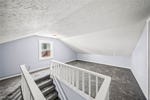 579 Main St, Conneaut, OH 44030 - additional living space with carpet, lofted ceiling, a textured ceiling, attic access, and baseboards