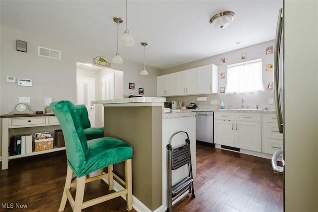 180 Elizabeth Pkwy, Akron, OH 44304 - kitchen featuring stainless steel appliances, a center island, a kitchen bar, white cabinets, and dark wood-type flooring