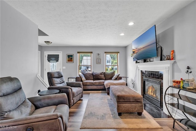 915 Devonshire Ave, Sheffield Lake, OH 44054 - living area with wood finished floors, a tile fireplace, recessed lighting, and a textured ceiling