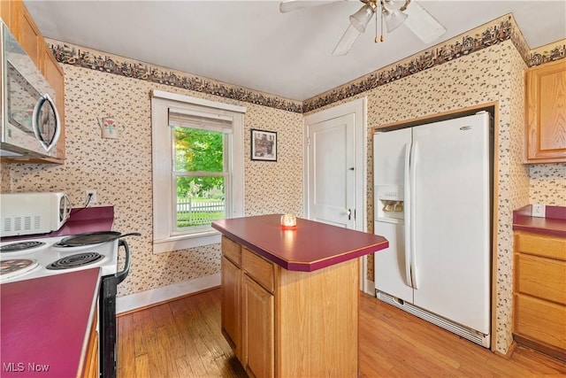 4723 Walnut St, Mantua, OH 44255 - kitchen featuring white appliances, wallpapered walls, light wood-style flooring, a center island, and a ceiling fan