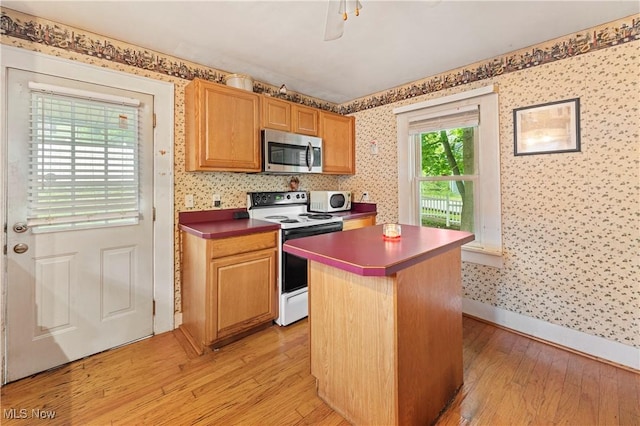 4723 Walnut St, Mantua, OH 44255 - kitchen featuring white appliances, wallpapered walls, light wood-style flooring, baseboards, and a center island