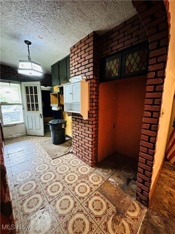 interior space with a textured ceiling and tile patterned flooring
