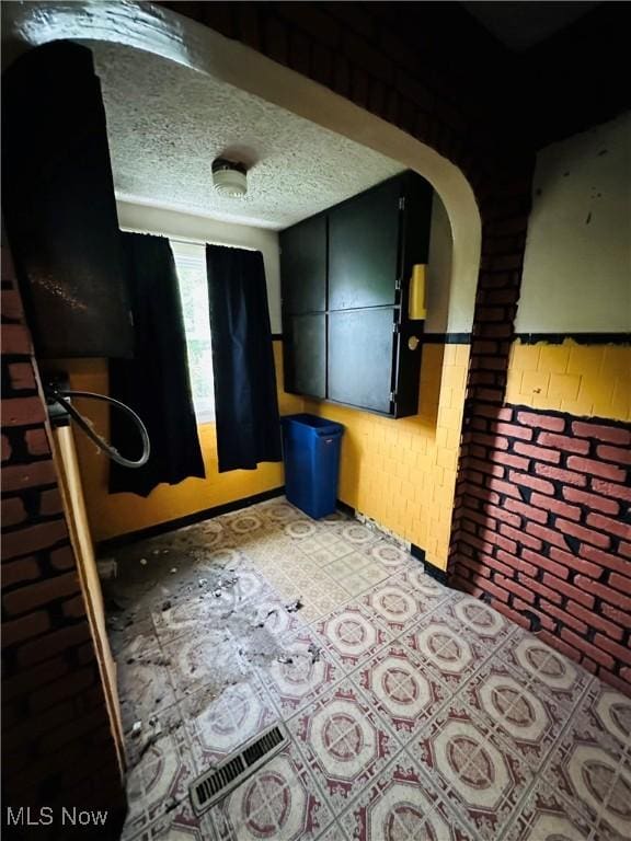 unfurnished bedroom featuring light floors and arched walkways