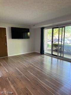spare room featuring wood finished floors and baseboards