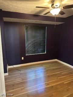 unfurnished room with baseboards, wood finished floors, and ceiling fan
