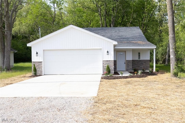 246 W Hamilton St, Oberlin, OH 44074 - view of front of house with stone siding, driveway, a shingled roof, an attached garage, and board and batten siding