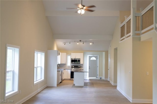 246 W Hamilton St, Oberlin, OH 44074 - kitchen with appliances with stainless steel finishes, high vaulted ceiling, light wood-style floors, decorative backsplash, and a sink