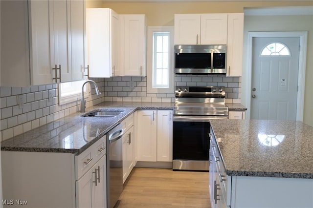 246 W Hamilton St, Oberlin, OH 44074 - kitchen with appliances with stainless steel finishes, a sink, healthy amount of natural light, and dark stone countertops