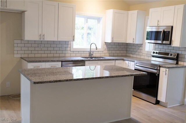 246 W Hamilton St, Oberlin, OH 44074 - kitchen with stainless steel appliances, a sink, light wood-style floors, and stone counters