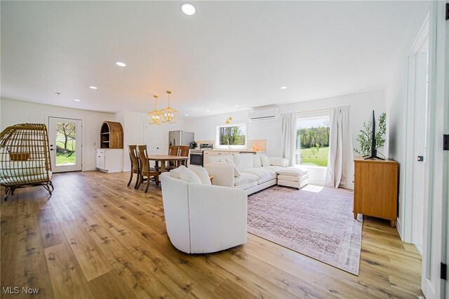 4043 Township Road 271, Killbuck, OH 44637 - living room with a wall mounted AC, light wood-style flooring, a chandelier, and recessed lighting